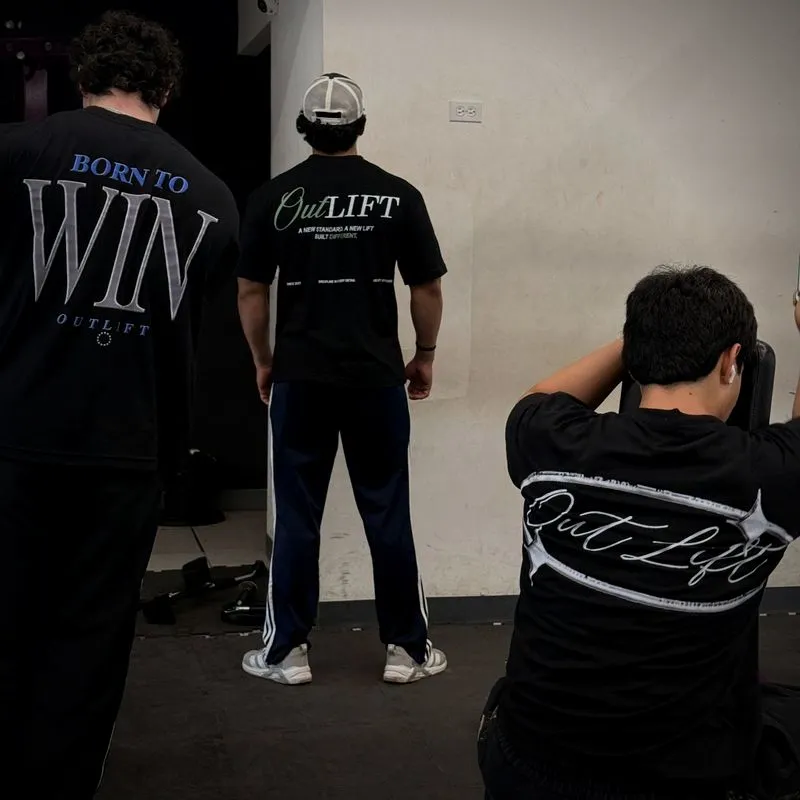 Tres atletas de la comunidad OUTLIFT de espaldas con las playeras Born to Win, New Standard y Orbit